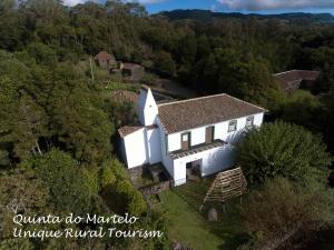 una vista aérea de una casa blanca en el bosque en Quinta Do Martelo en Angra do Heroísmo