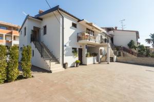 a white house with stairs and a patio at Alex Deluxe Apartments on Beach in Poreč