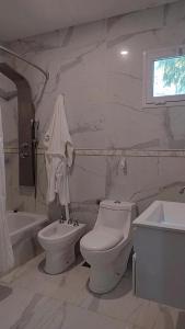 a bathroom with a toilet and a sink and a tub at Like at Home Ezeiza in Ezeiza