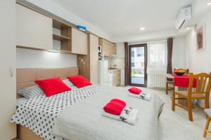 a bedroom with a large bed with red pillows on it at Alex Deluxe Apartments on Beach in Poreč