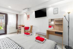 een slaapkamer met een bed met rode kussens erop bij Alex Deluxe Apartments on Beach in Poreč