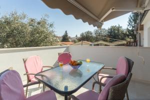- une table avec des chaises et une corbeille de fruits sur le balcon dans l'établissement Alex Deluxe Apartments on Beach, à Poreč