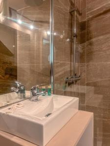 a bathroom with a white sink and a shower at Casas Sebastião - Tourist House in Caminha