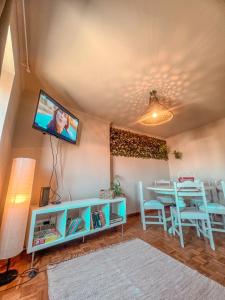 sala de estar con mesa y TV en la pared en Casas Sebastião - Tourist House, en Caminha