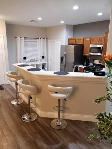 a kitchen with a large island with bar stools at A - Fully remodeled and professionally decorated in Las Vegas