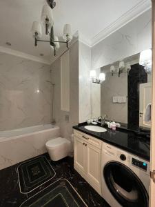 La salle de bains est pourvue d'un lavabo et d'un lave-linge. dans l'établissement Apartments in the Babylon residential complex, à Almaty