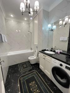 a bathroom with a toilet sink and a washing machine at Apartments in the Babylon residential complex in Almaty