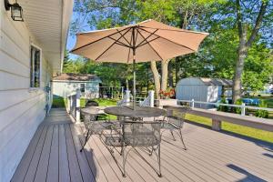 a table and chairs with an umbrella on a deck at Lake Huron House with Grill and Beach Access! in East Tawas