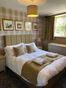 a bedroom with a large bed with two towels on it at Irton Hall in Eskdale