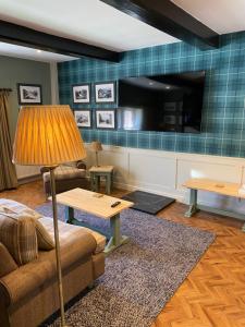 a living room with a couch a table and a tv at Irton Hall in Eskdale