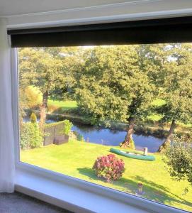 a window with a view of a garden and a lake at Caithness Holiday Home in Pontypool