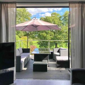a patio with a table and an umbrella at Caithness Holiday Home in Pontypool