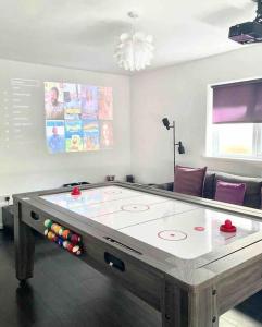 a ping pong table in a living room with at Caithness Holiday Home in Pontypool