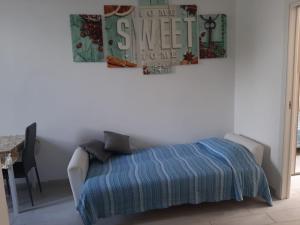 a bedroom with a bed with a blue blanket and a table at Home Sweet Home in Civitavecchia +1 photo