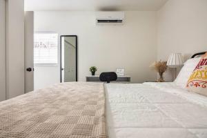 マイアミにあるSleeps 3, Cozy, Boho Style, in the heart of Miami -free parkingの白いベッドルーム(大型ベッド1台、椅子付)