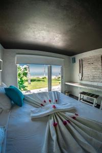 Una cama blanca con una toalla y una ventana en Depraia Beach House - Icaraizinho en Icaraí