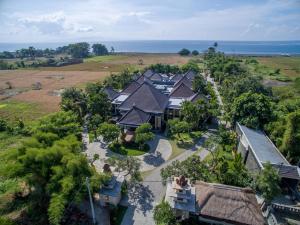 een luchtzicht op een huis met de oceaan op de achtergrond bij New Horizon Rice Fields & Beach Villas in Bali in Siyut