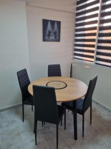 uma mesa de madeira e cadeiras num quarto em Luxury Apartments em Bacau