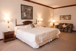 a bedroom with a large white bed and a chair at Nobile Suites Excelsior Asuncion in Asunción +49 photos