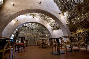 une chambre avec une rangée de chaises dans une grotte dans l'établissement Hotel Cervaria, à Cervera del Río Alhama