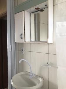 a bathroom with a white sink and a mirror at Pé na areia in Ilha Comprida