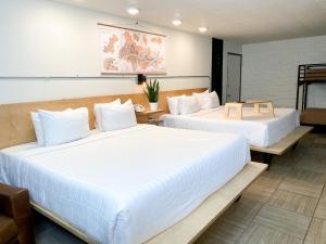 2 Betten in einem Hotelzimmer mit weißer Bettwäsche in der Unterkunft Hotel Corvallis in Corvallis