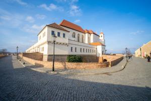 a large white building on a brick street at Penzion Village Peace #29 by Goodnite cz - U Libušky in Brno
