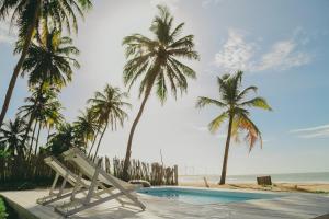 un complejo con piscina y palmeras en Depraia Beach House - Icaraizinho en Icaraí