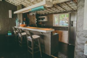 Una cocina con una encimera con taburetes. en Depraia Beach House - Icaraizinho, en Icaraí 24 fotos más