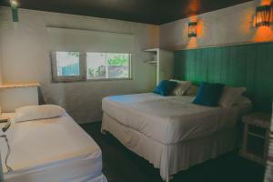 Un dormitorio pequeño con dos camas y una ventana. en Depraia Beach House - Icaraizinho, en Icaraí