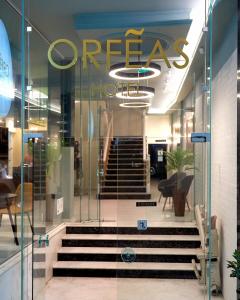 克桑西的住宿－Hotel Orfeas，门上和楼梯上标有标志的商店
