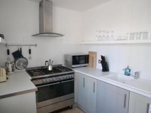 una cucina con piano cottura forno superiore accanto a un lavandino di luxury 3 bathroom cinema and sauna a Seaford