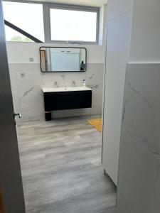 bagno con lavandino e specchio di Loft épuré avec parking privé. a Saint-Symphorien-dʼOzon