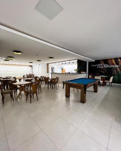 a pool table in a room with tables and chairs at Resort Ecoar in Gaspar