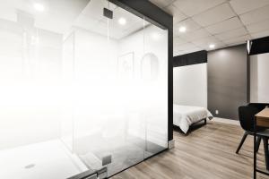 a bedroom with a glass door leading to a bed at Hygie Boutique Hotel in Montreal