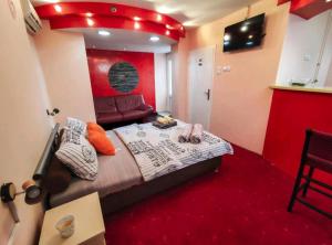 een slaapkamer met een bed en een bank erin bij S. A. L. Prenociste in Zrenjanin
