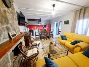 a living room with yellow couches and a kitchen at El lazarillo de tormes in Escalona