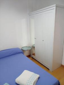 sypialnia z niebieskim łóżkiem i szafą w obiekcie Apartamento 2 dormitorios cerca del Wizink w Madrycie