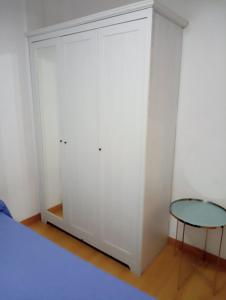 biała szafa ze stołem i łóżkiem w obiekcie Apartamento 2 dormitorios cerca del Wizink w Madrycie