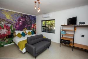 a bedroom with a bed with a large painting on the wall at Casa iLanga guesthouse in Somerset West