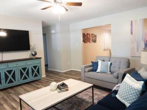 ein Wohnzimmer mit einem Sofa und einem TV in der Unterkunft Subtle comfort and style in quiet neighborhood. in Joplin