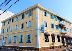 a yellow building on the corner of a street at Grande Hotel Bragança in Bragança Paulista