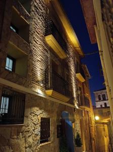 - un vieux bâtiment en pierre avec des balcons la nuit dans l'établissement Hotel Cervaria, à Cervera del Río Alhama