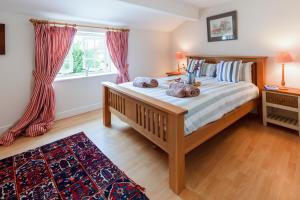 a bedroom with a large bed and a window at No. 4 Back Lane - Norfolk Cottage Agency in Burnham Market