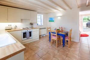 a kitchen and dining room with a table and chairs at No. 4 Back Lane - Norfolk Cottage Agency in Burnham Market