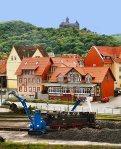 a train on the tracks in front of a town at Altora Eisenbahn Themenhotel in Wernigerode