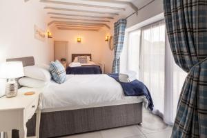 1 dormitorio con 2 camas y ventana en Meadow Barn - Norfolk Cottage Agency en North Walsham