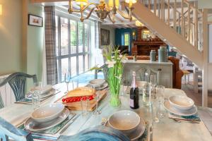 una mesa de comedor con platos y una botella de vino en Meadow Barn - Norfolk Cottage Agency en North Walsham