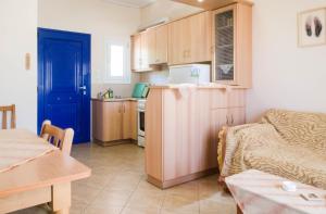 cocina con puerta azul y sala de estar en STUDIOS ATHENA en Megalochori