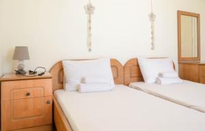 two beds with white pillows on them in a room at STUDIOS ATHENA in Megalochori
